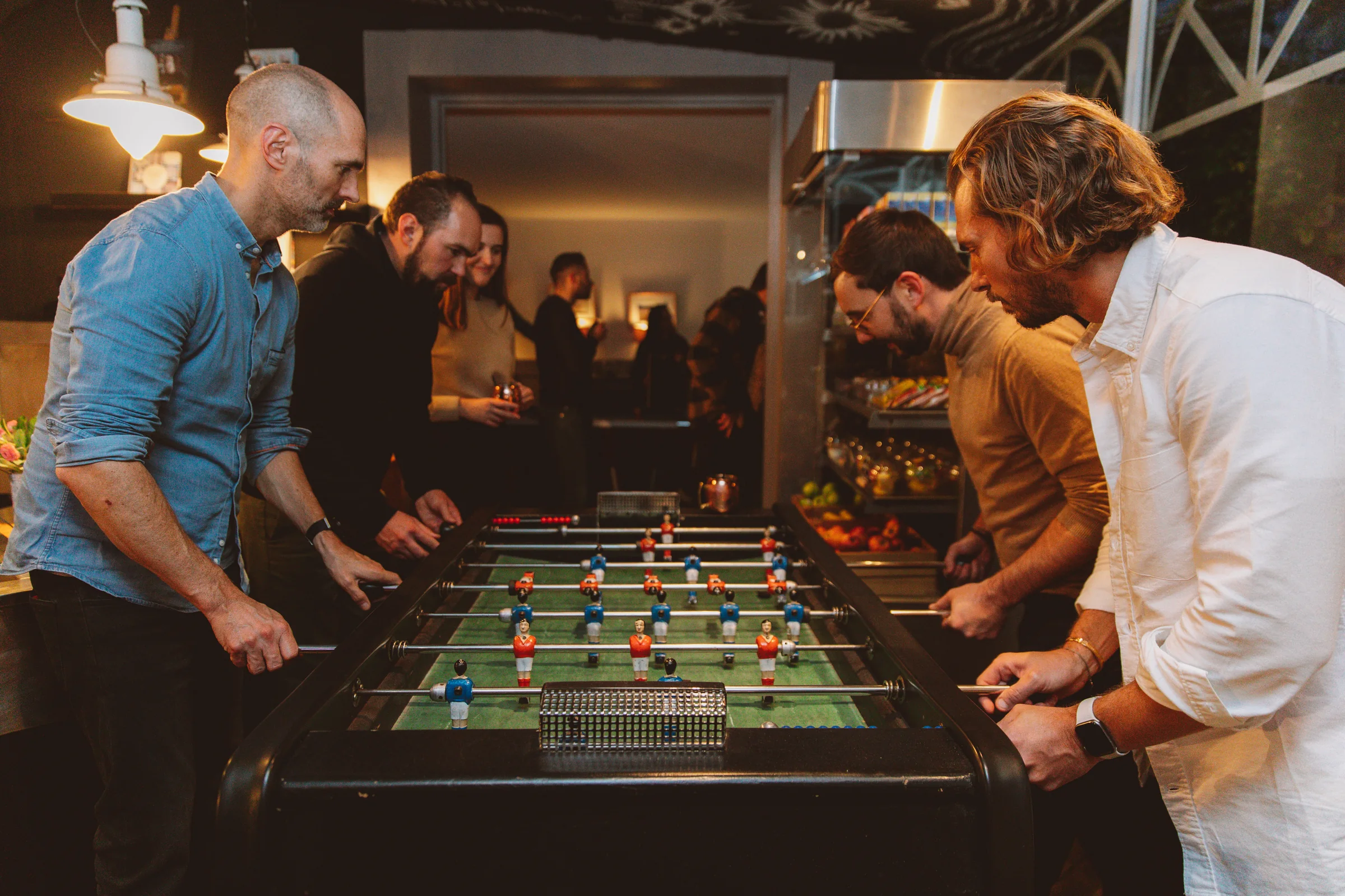 Participants jouant ensemble au baby-foot pendant un team building